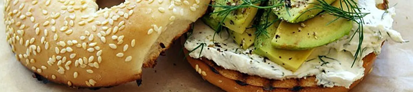 Bagel with cream cheese, avocado, and dill.