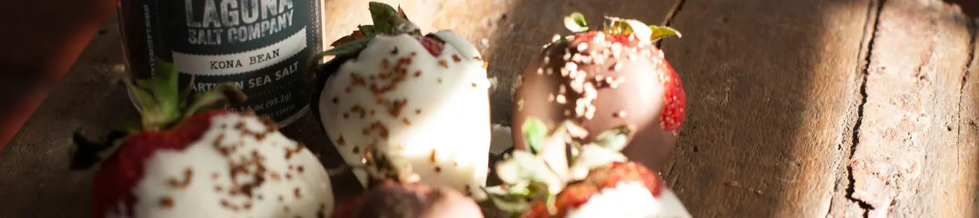 Chocolate-covered strawberries on wooden surface.