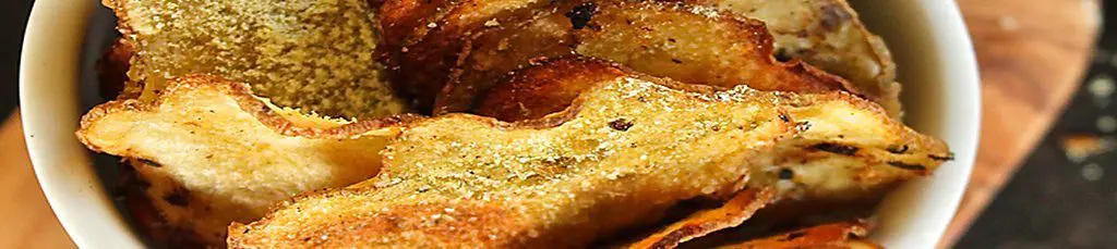 Homemade seasoned potato chips in bowl.