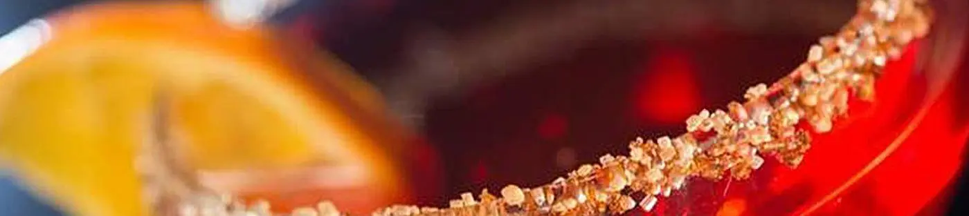 Cocktail with sugared rim and orange slice.