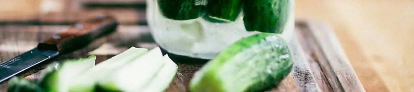 Sliced cucumbers on a wooden cutting board.