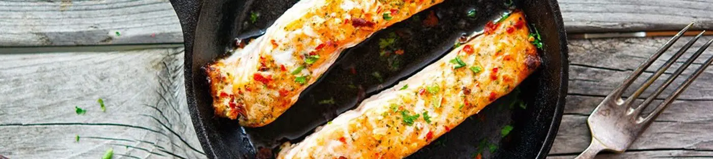 Grilled salmon fillets in a cast-iron skillet.